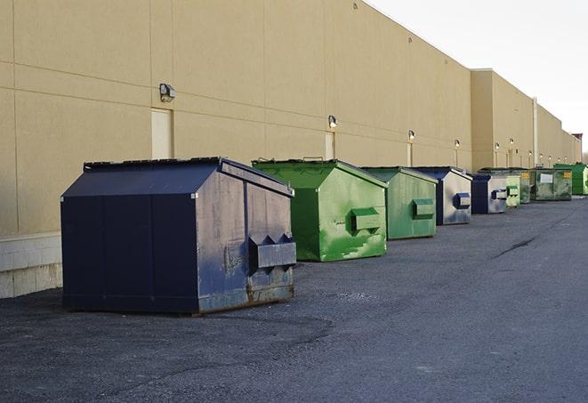 tilted front-load dumpsters being emptied by waste management workers in Alice